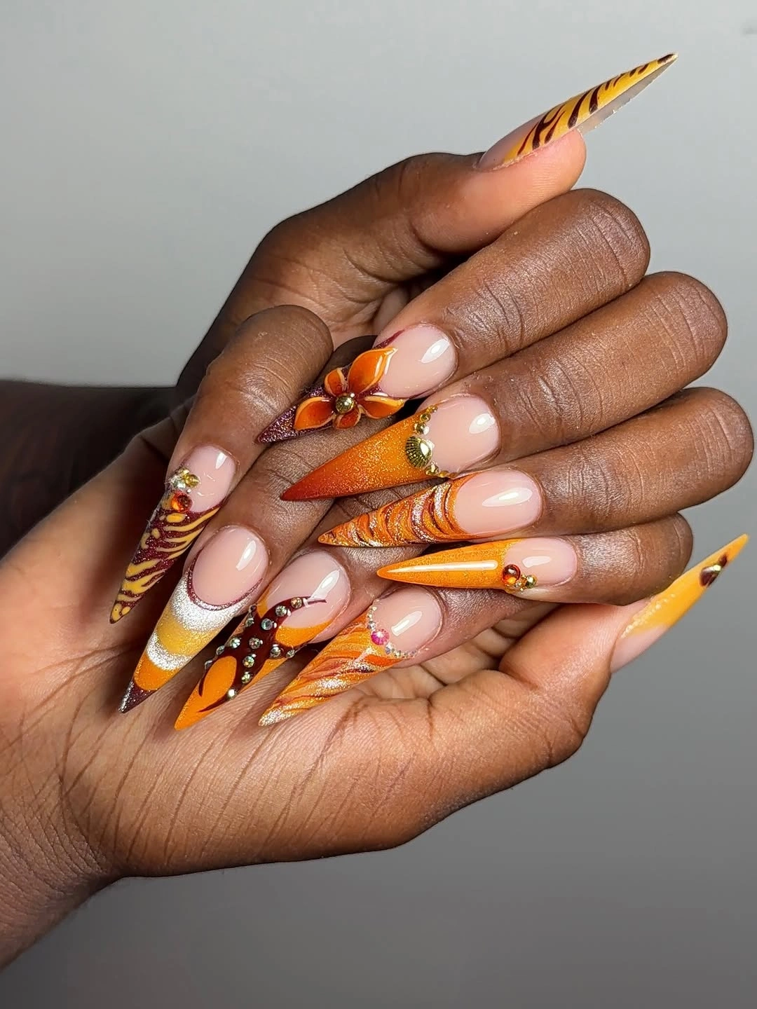 Long orange burgundy and ivory nails with striped autumn art