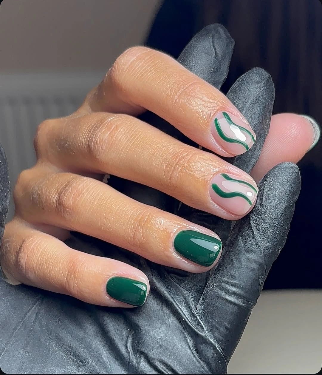 Nude almond nails with saturated green wavy French tips