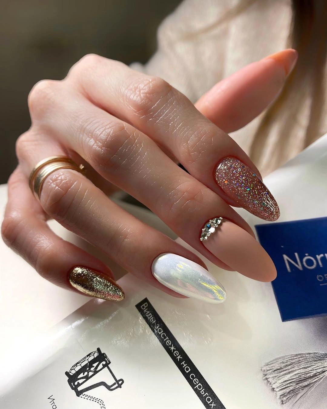 Long almond nails with pearly white rose gold glitter and gem