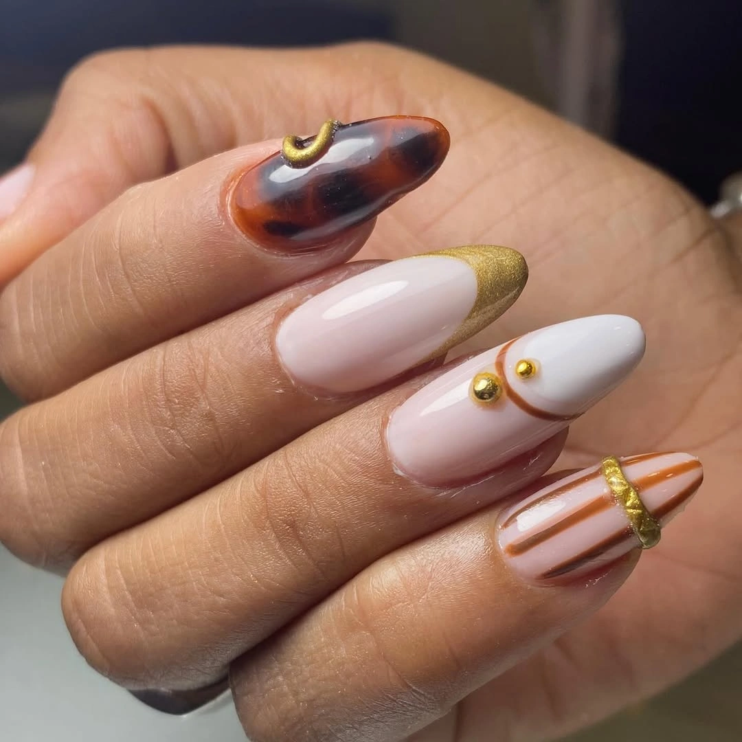 Long almond nails with tortoiseshell brown accents and gold lines