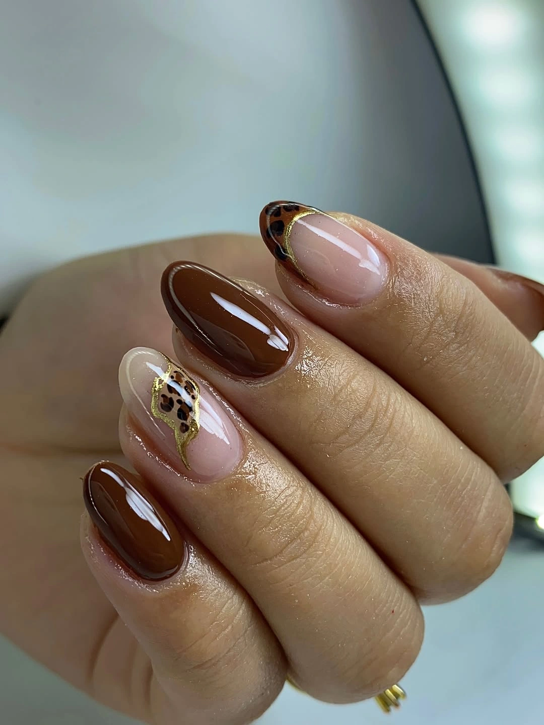 Medium chocolate almond nails with one framed leopard accent