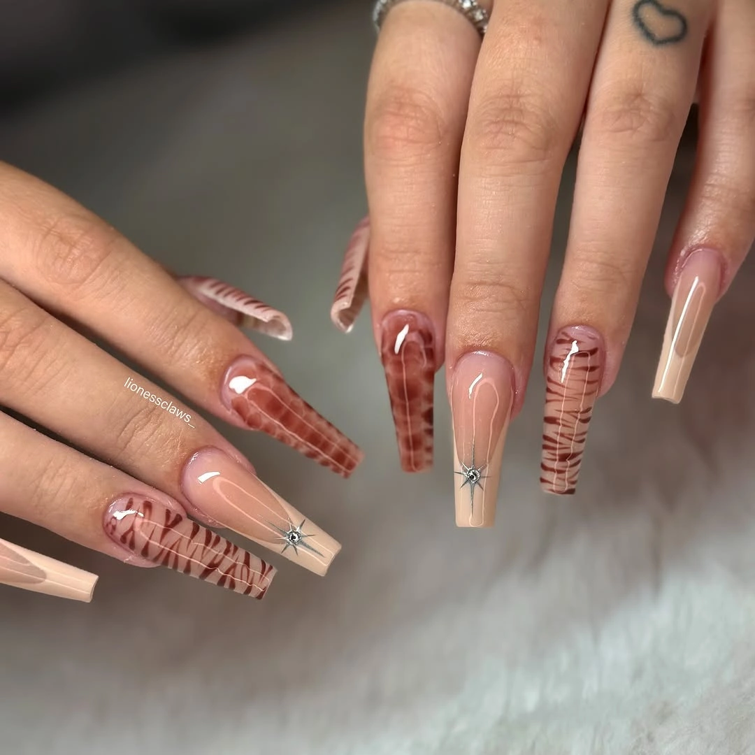 Long blush coffin nails with warm line drawings and plaid panels