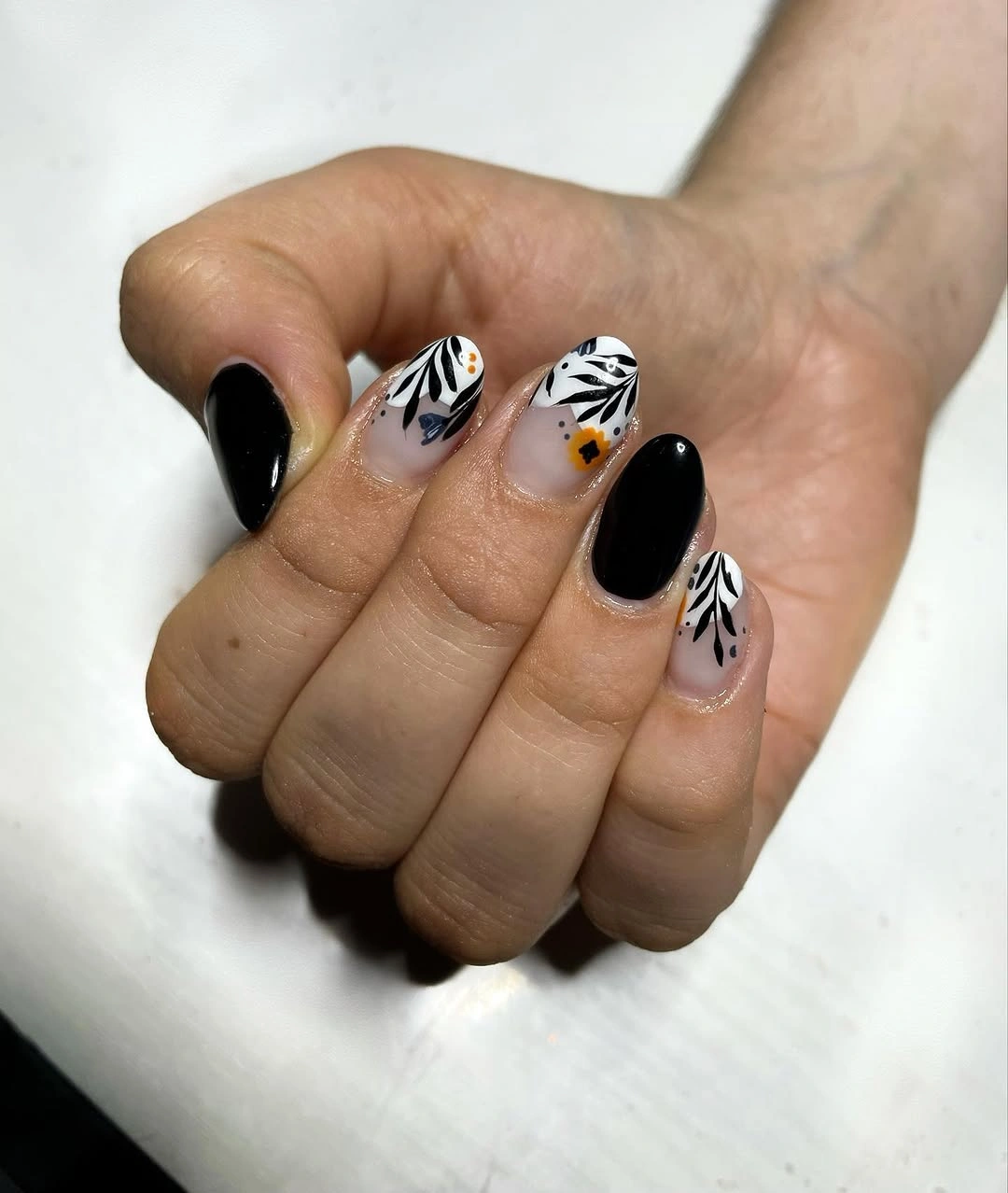 Short black oval nails with white abstract striped accents