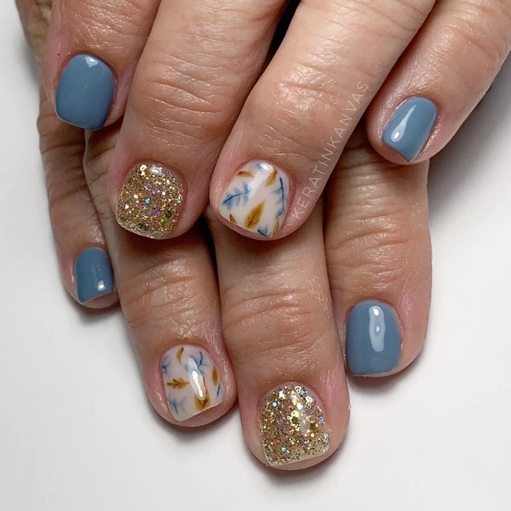 Short periwinkle square nails with glitter and blue yellow accents