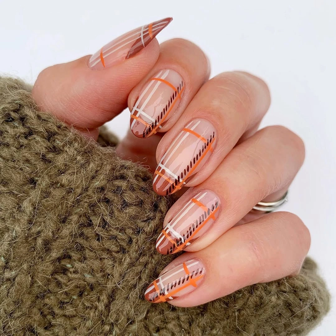 Long coral coffin nails with cream tan stripes and a green accent