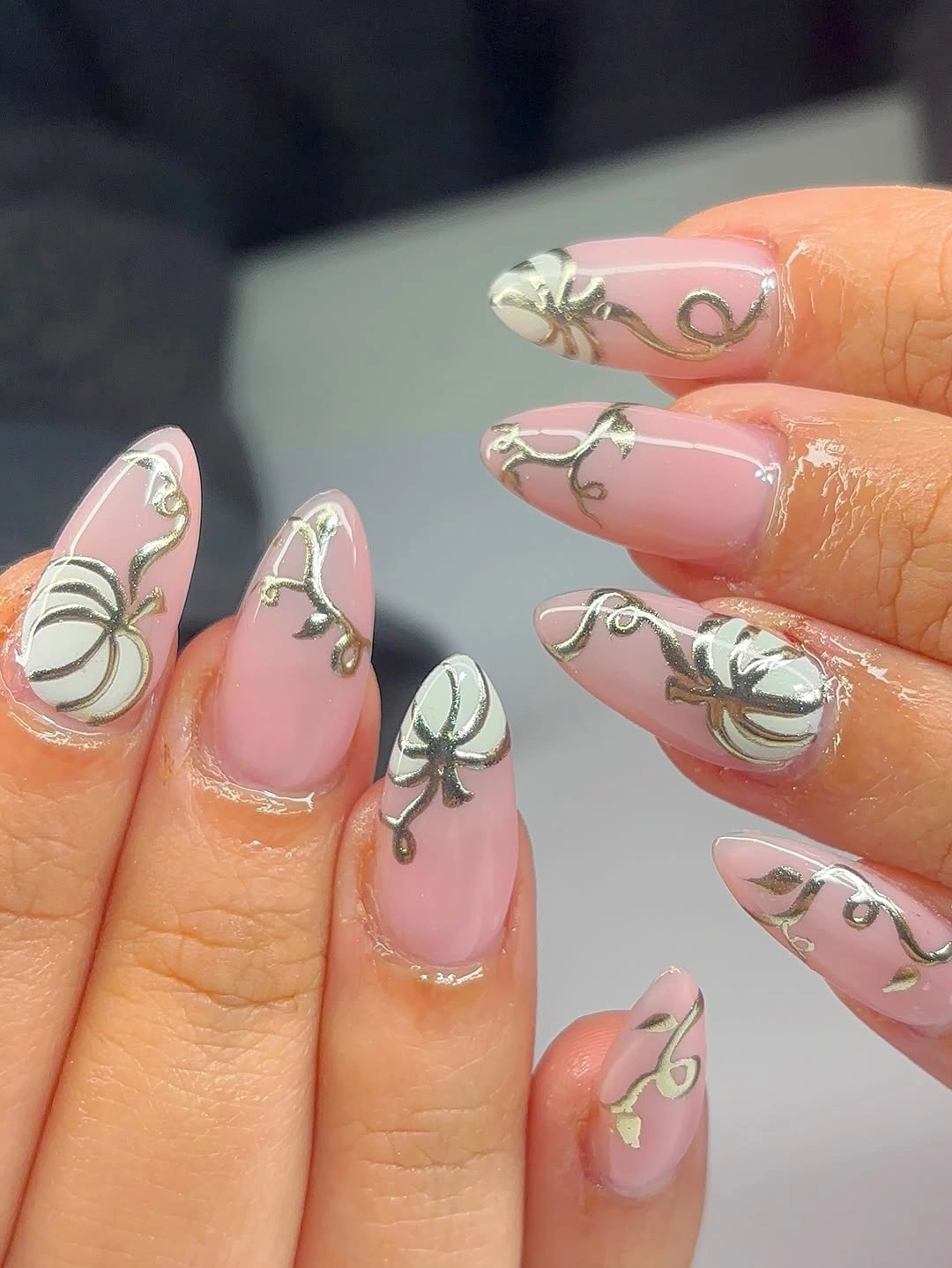 Long pink almond nails with soft gray seasonal line art and dark accents