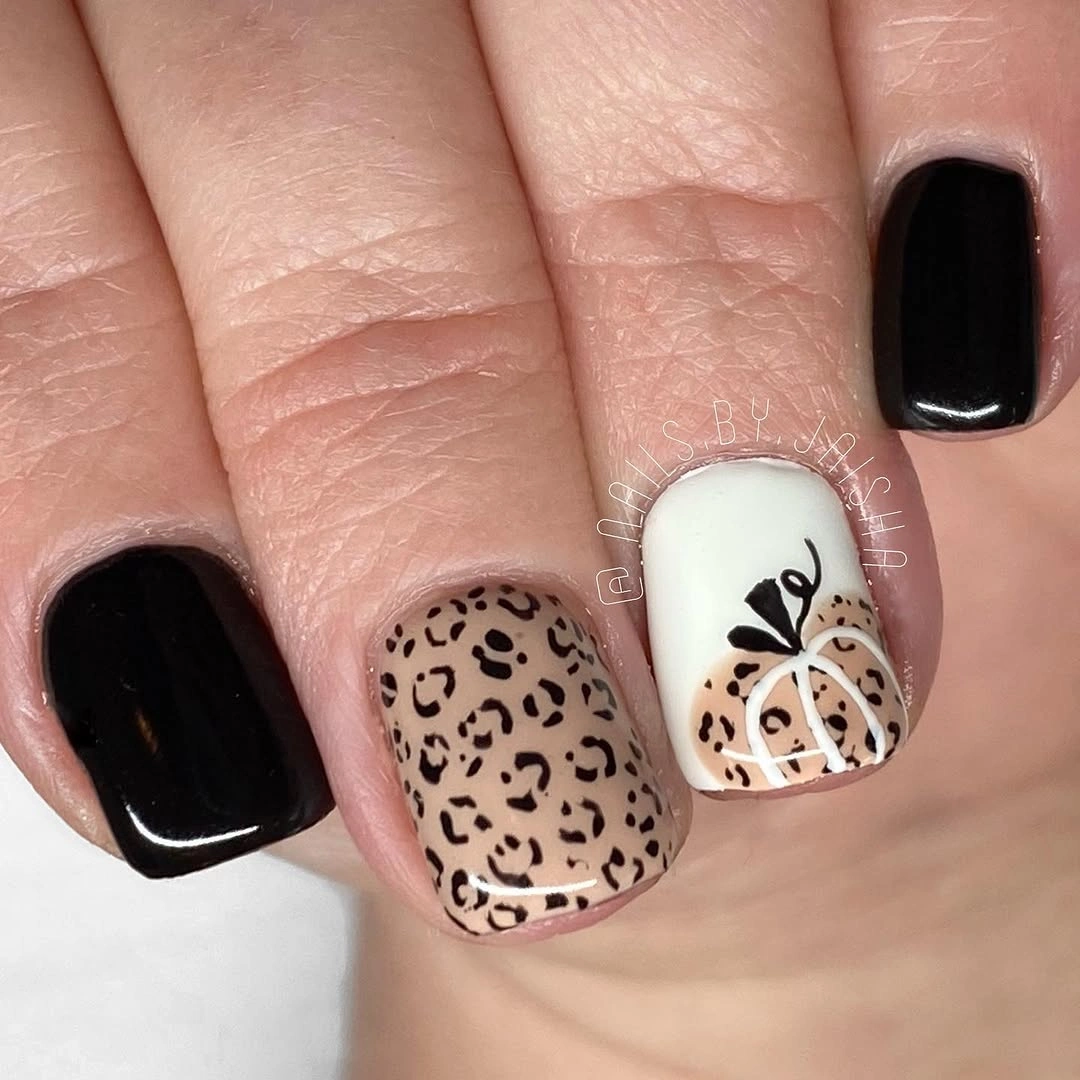 Short square black white and nude nails with a spotted accent