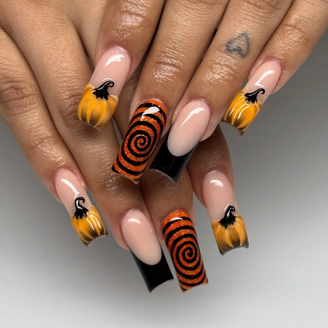 Long nude stiletto nails with orange and black concentric accents
