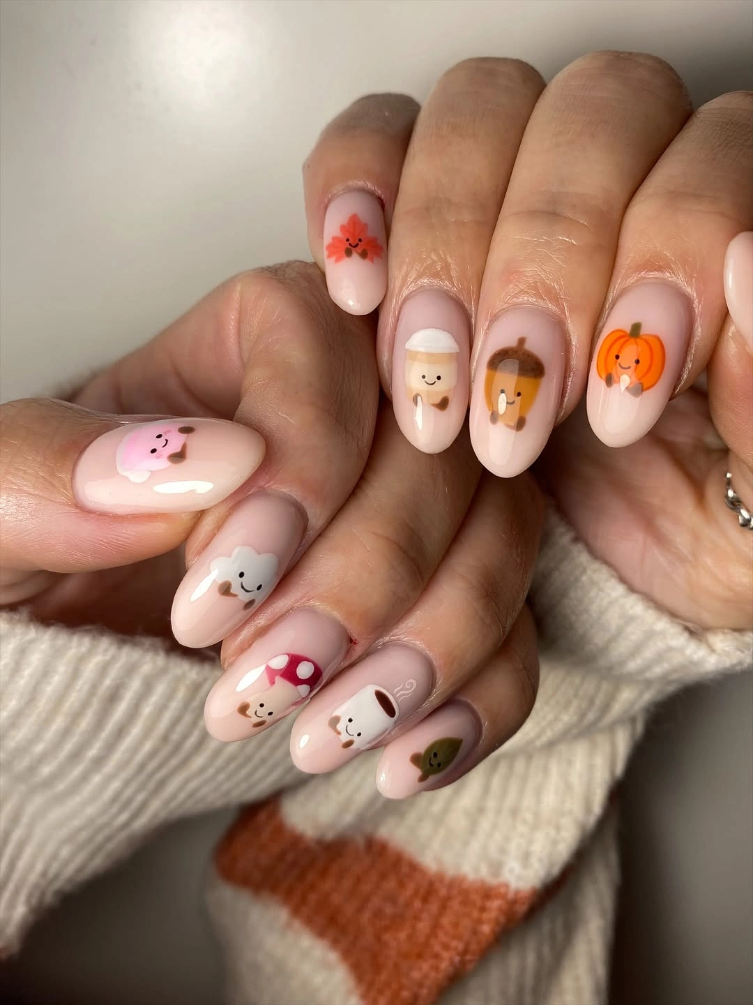 Medium almond cream pink nails with tiny orange brown and black fall symbols