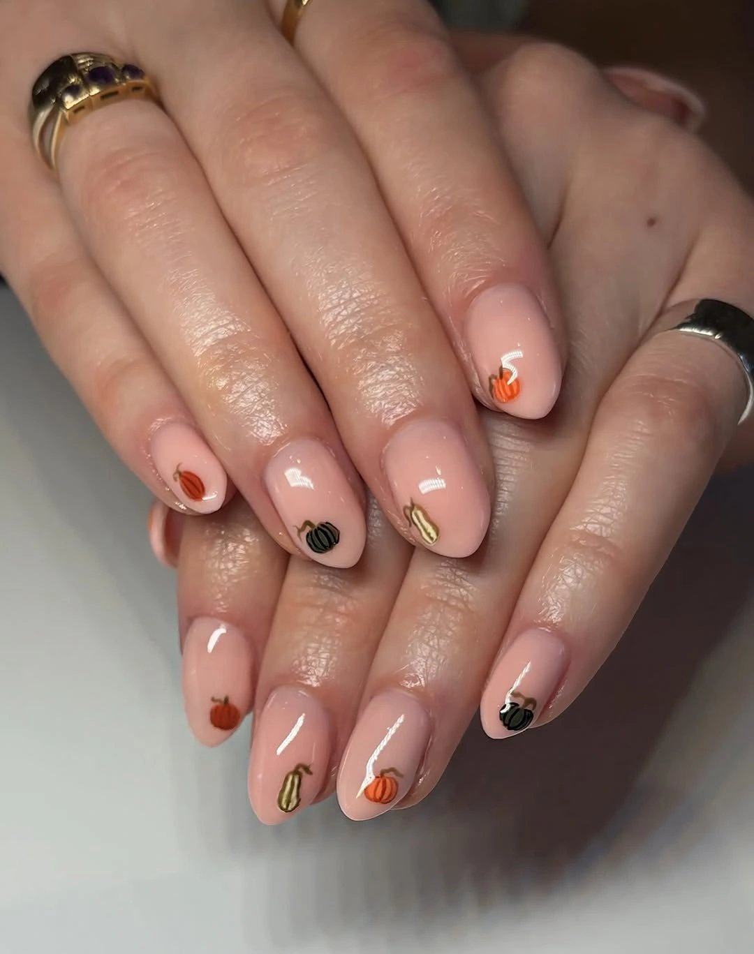 Short rounded pink nude nails with tiny centered orange seasonal accents