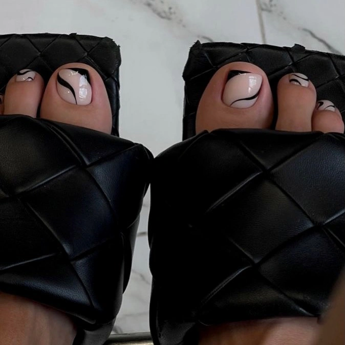 Nude pedicure with black swirl line art