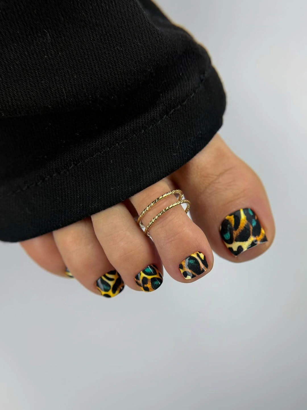Black pedicure with teal and orange abstract markings