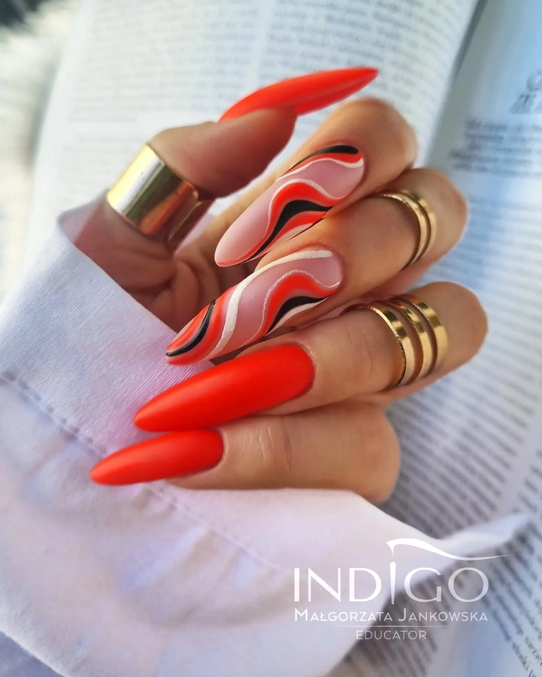 Matte red almond nails with flowing accent lines