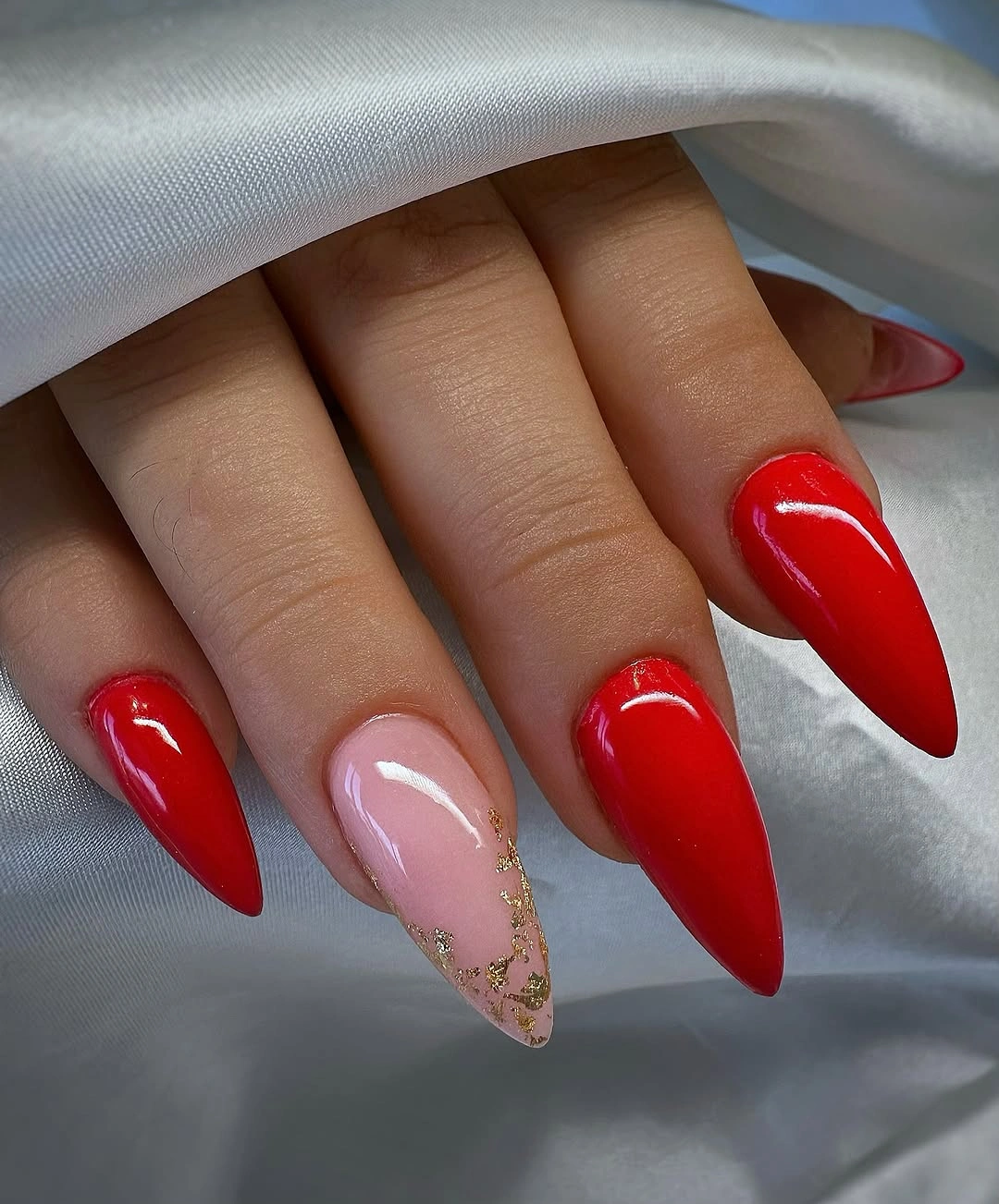Bright red pointed nails with gold framed accent
