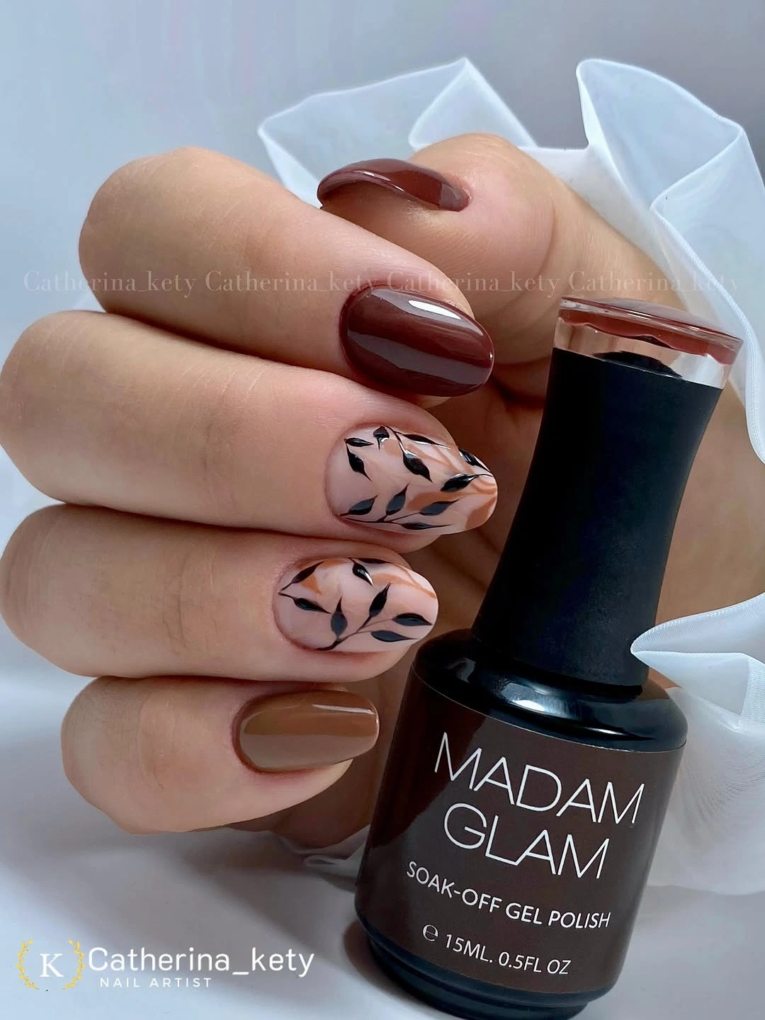 Medium almond brown and nude nails with dark botanical linework