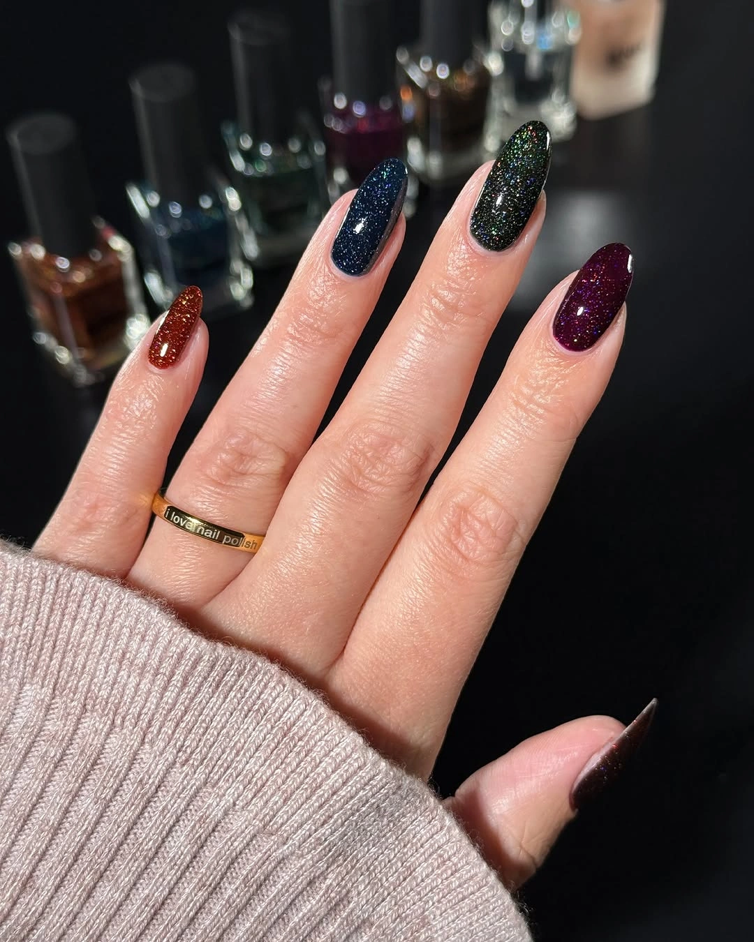 Long almond nails in navy green red and burgundy jewel-tone glitter