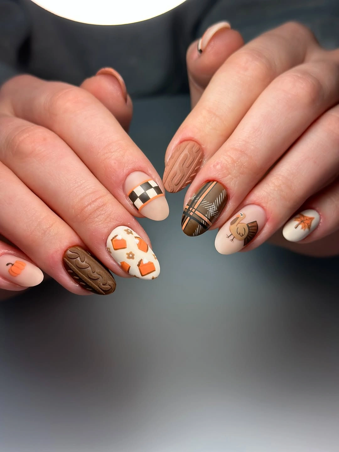 Medium almond brown cream orange and black nails with seasonal details