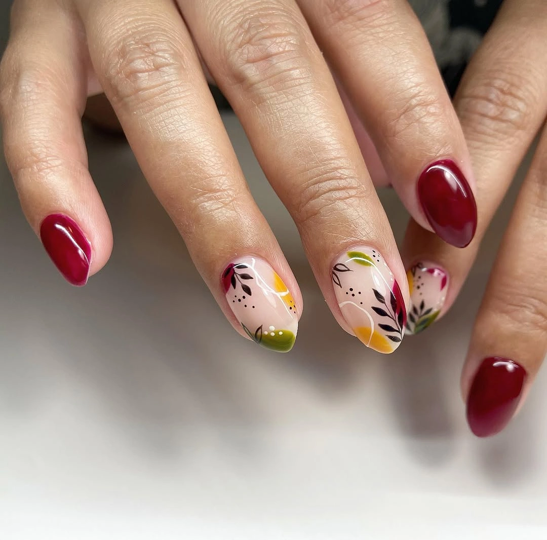 Medium almond nails with deep red olive cream and black abstract accents