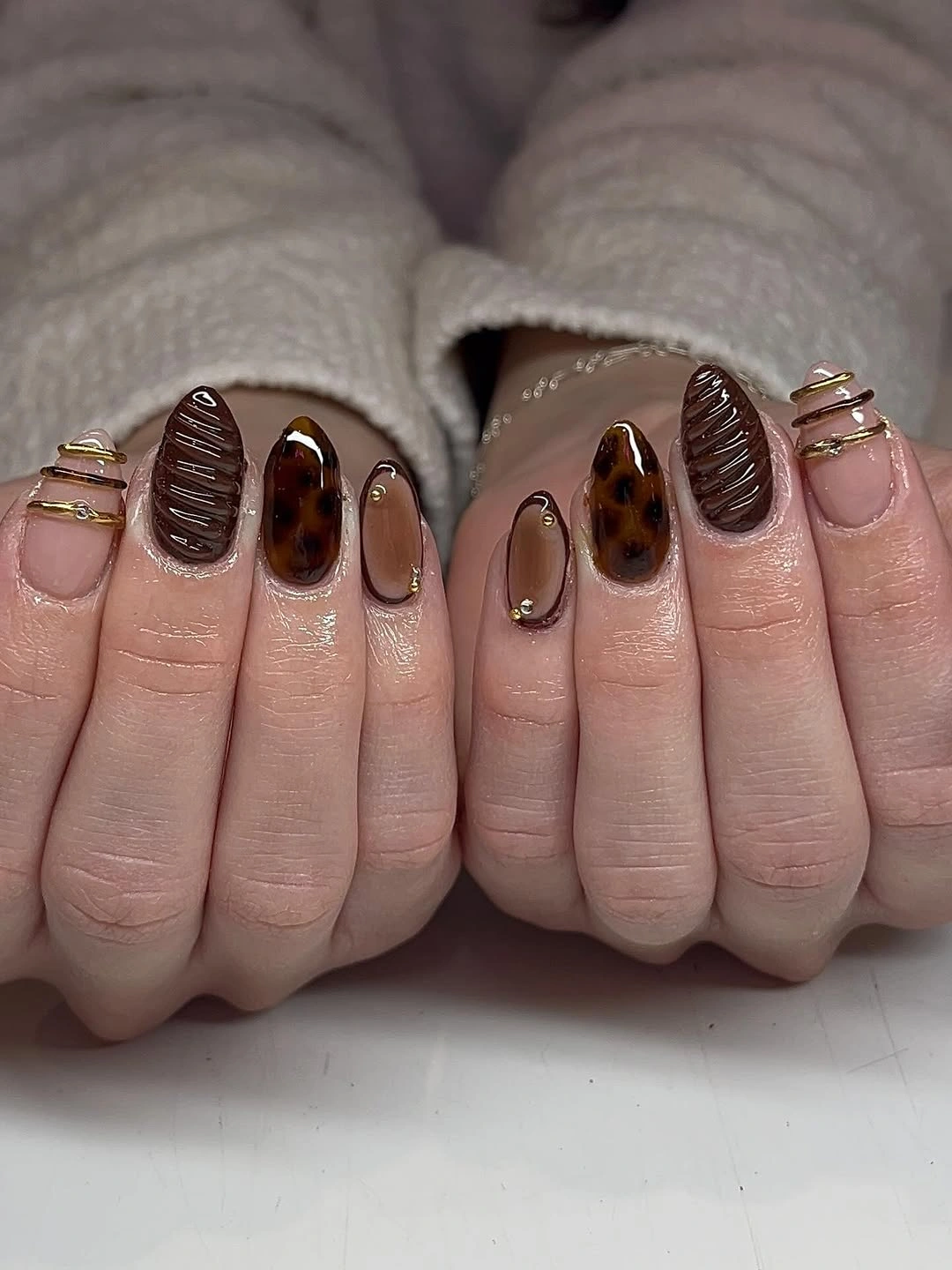 Short almond cream and chocolate nails with dark textured accents