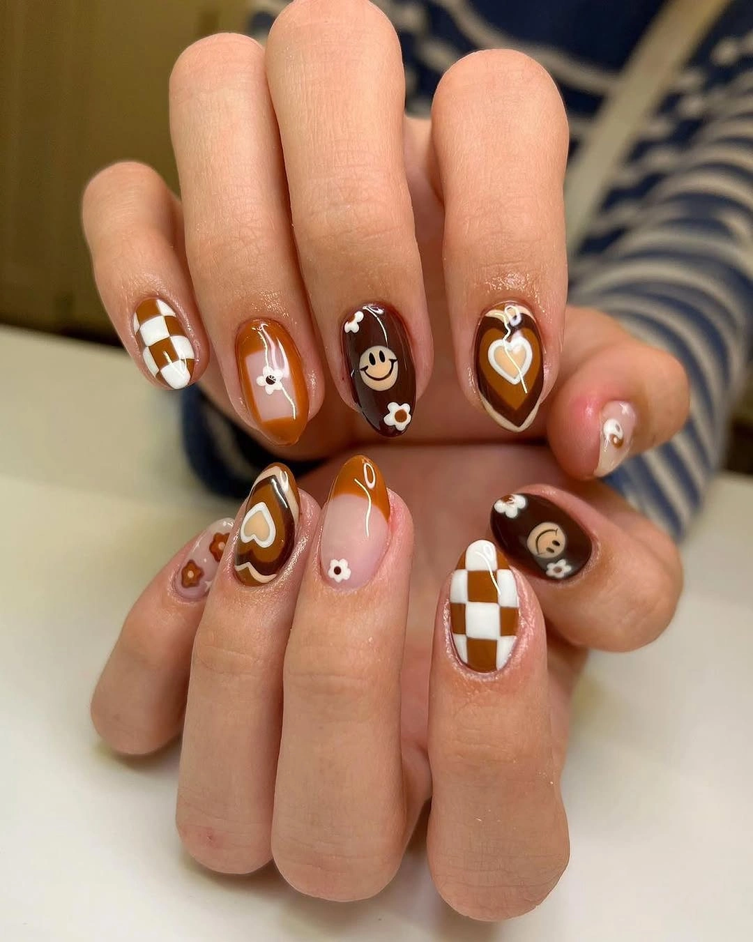 Short almond caramel and cream nails with checkerboard accents