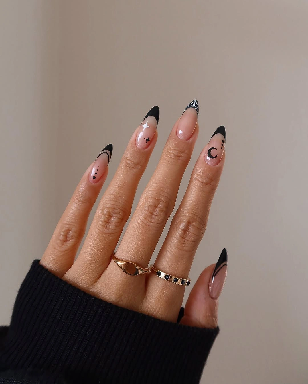 Long almond nails with sheer nude bases and dark pointed tips