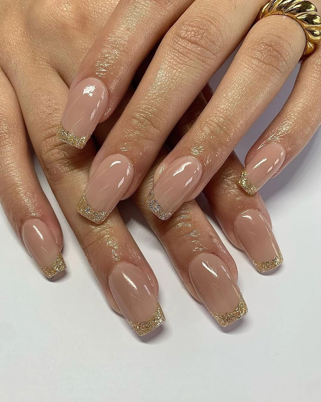 short nude coffin nails with narrow shimmering gold tips