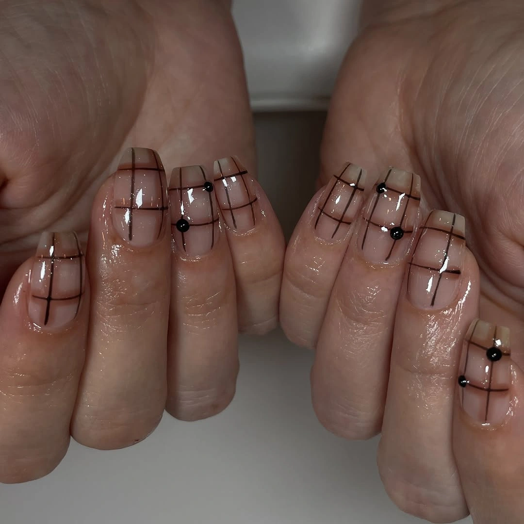 short nude coffin nails with fine brown grid lines and dots
