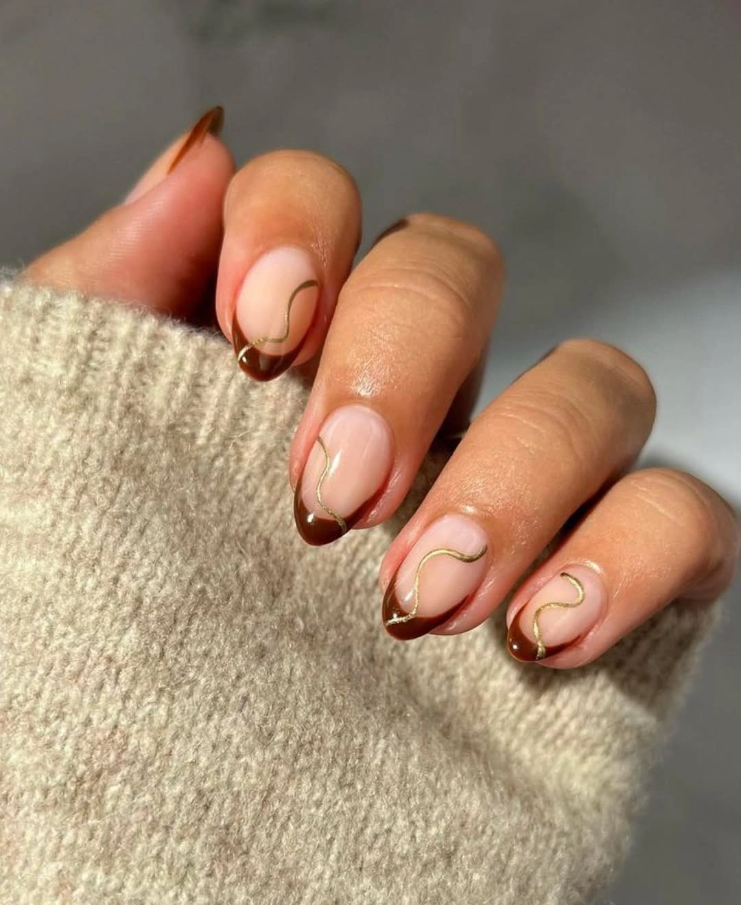 Chocolate French short almond nails with gold curves