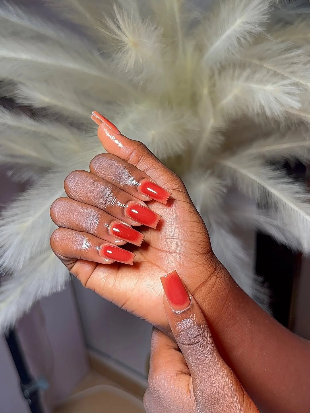 Short coral nails with small white flower-like accent details