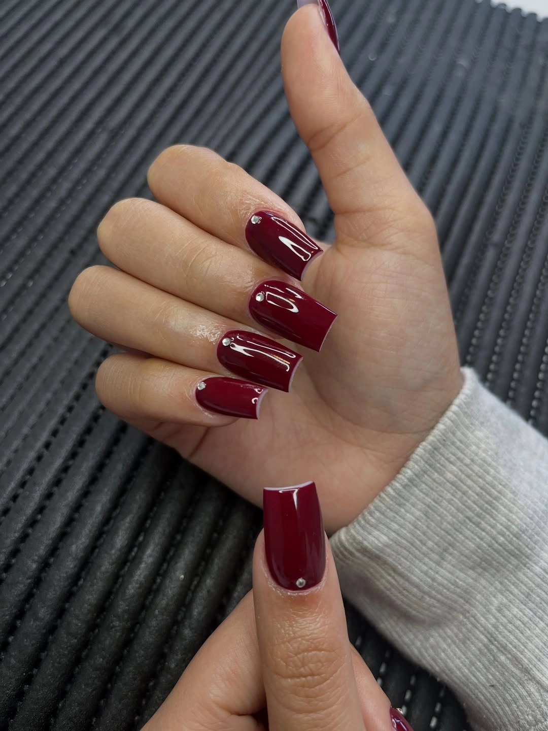Deep wine red square nails with minimal narrow white edge accents