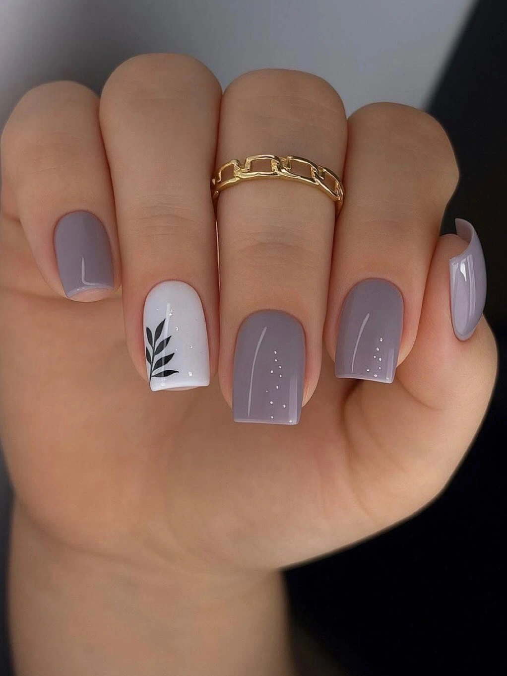 Short lavender square nails with a white botanical leaf accent