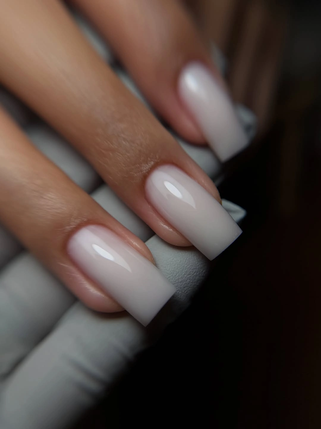Long square nails fading softly from nude into frosted white tips