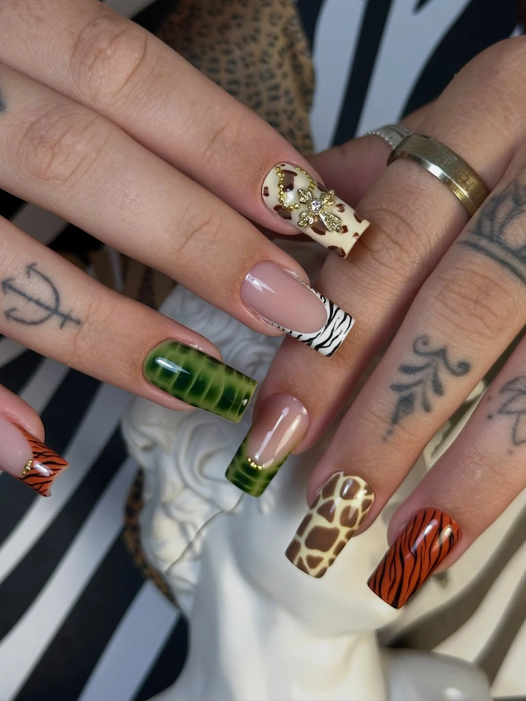 Nude square nails with mixed leopard zebra and tiger-inspired accents