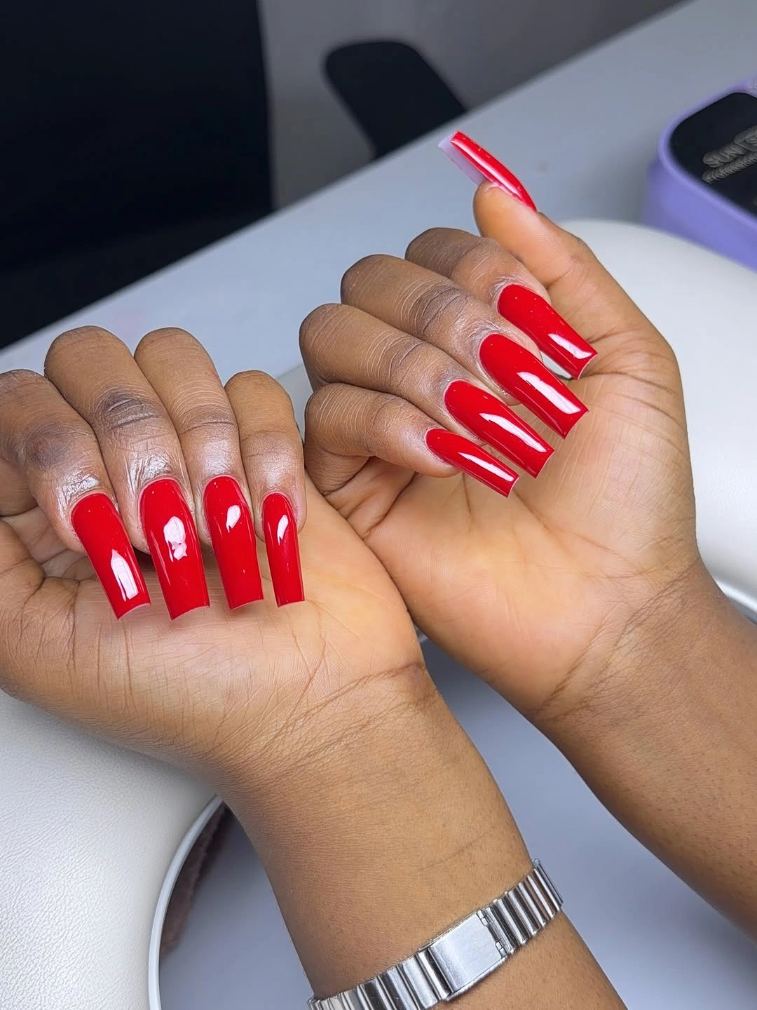 Bright red square nails with small crisp white graphic accents