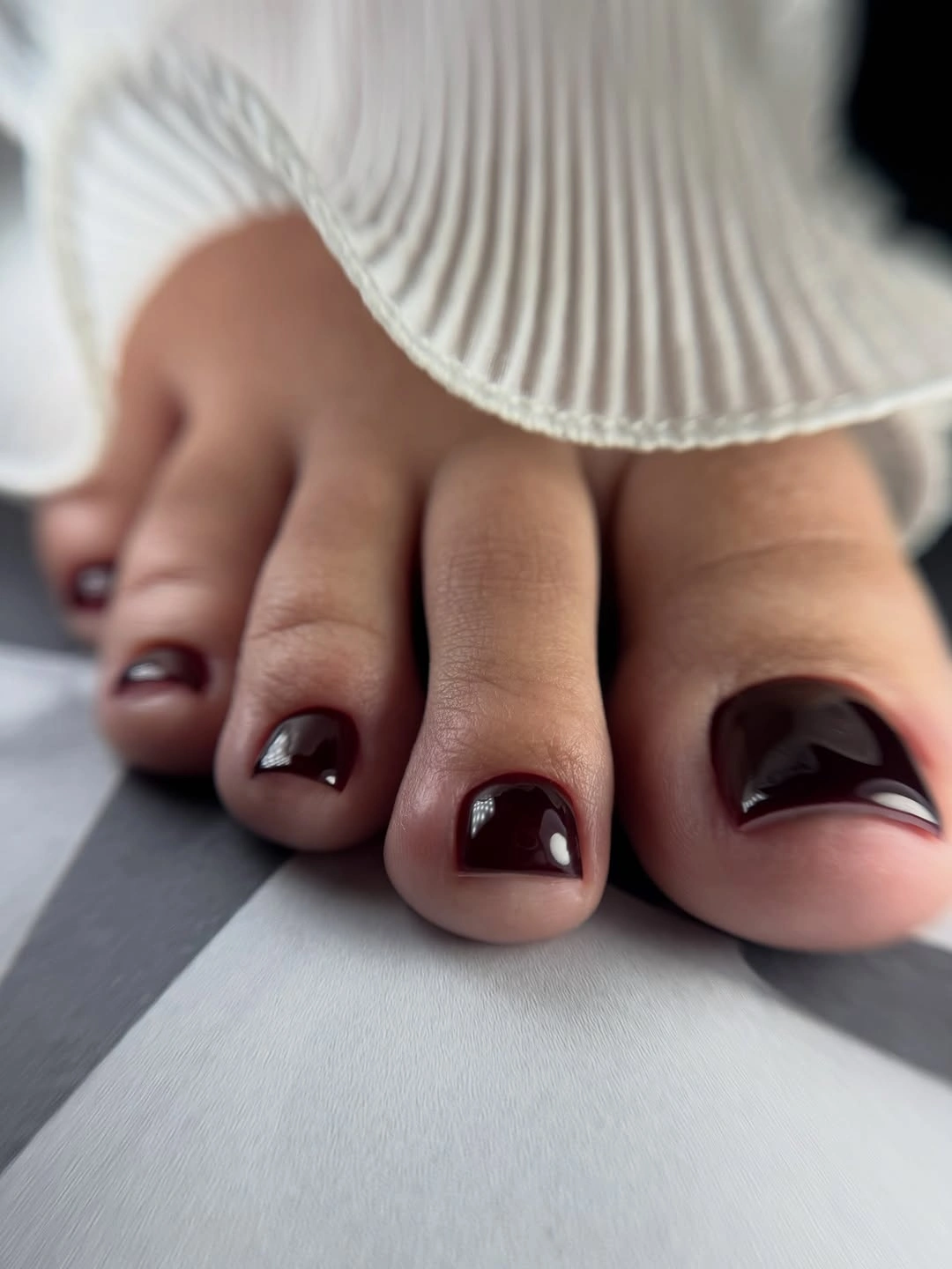 Short matte coral red toenails with one tiny bright accent