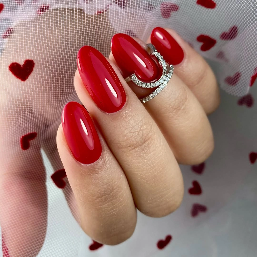 Long pink coffin nails with deep red glitter tips and bow accents