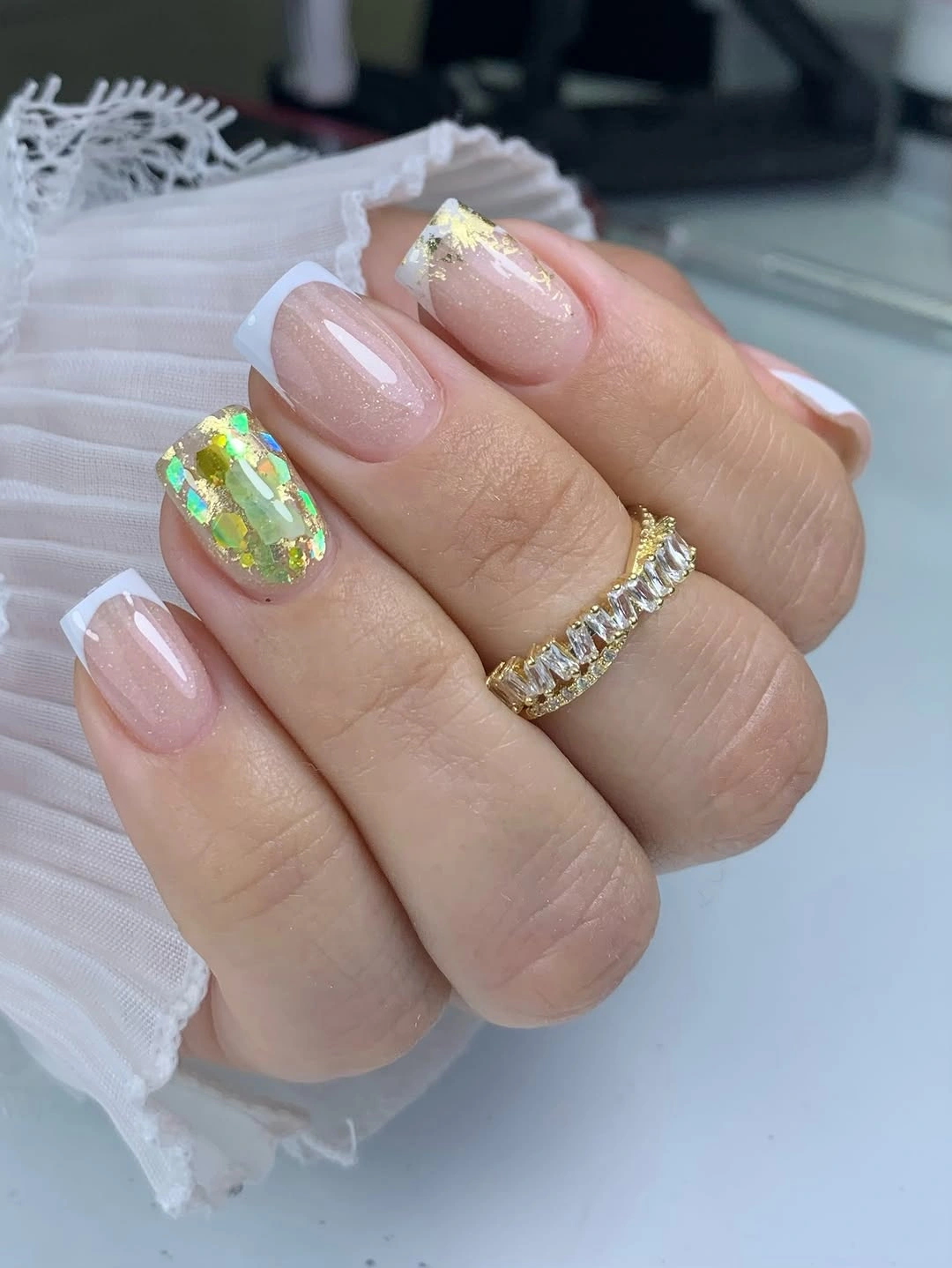 Medium nude oval nails with reflective silver wing like accents