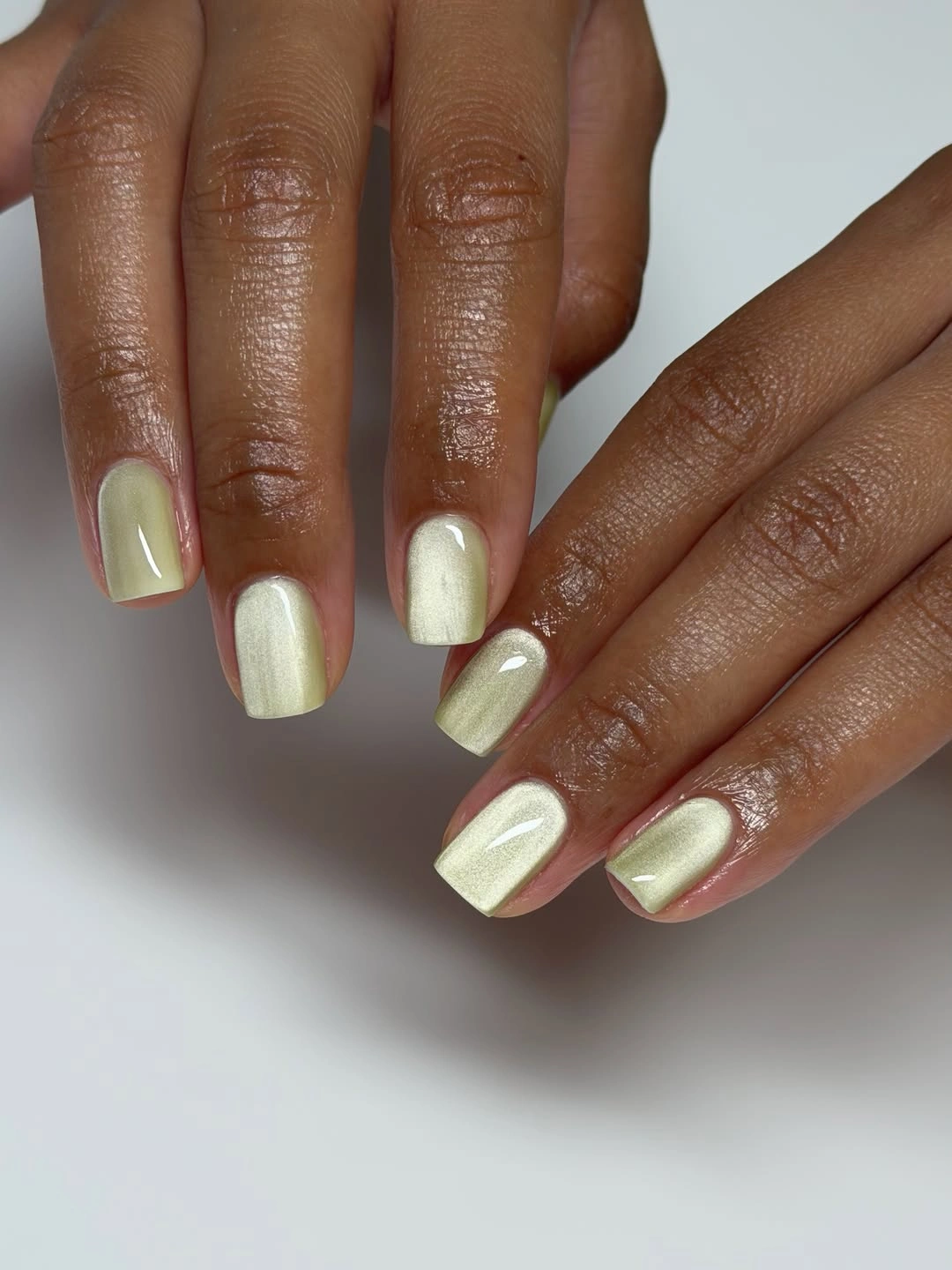 Long almond nails with blush bases and reflective silver blue French curves