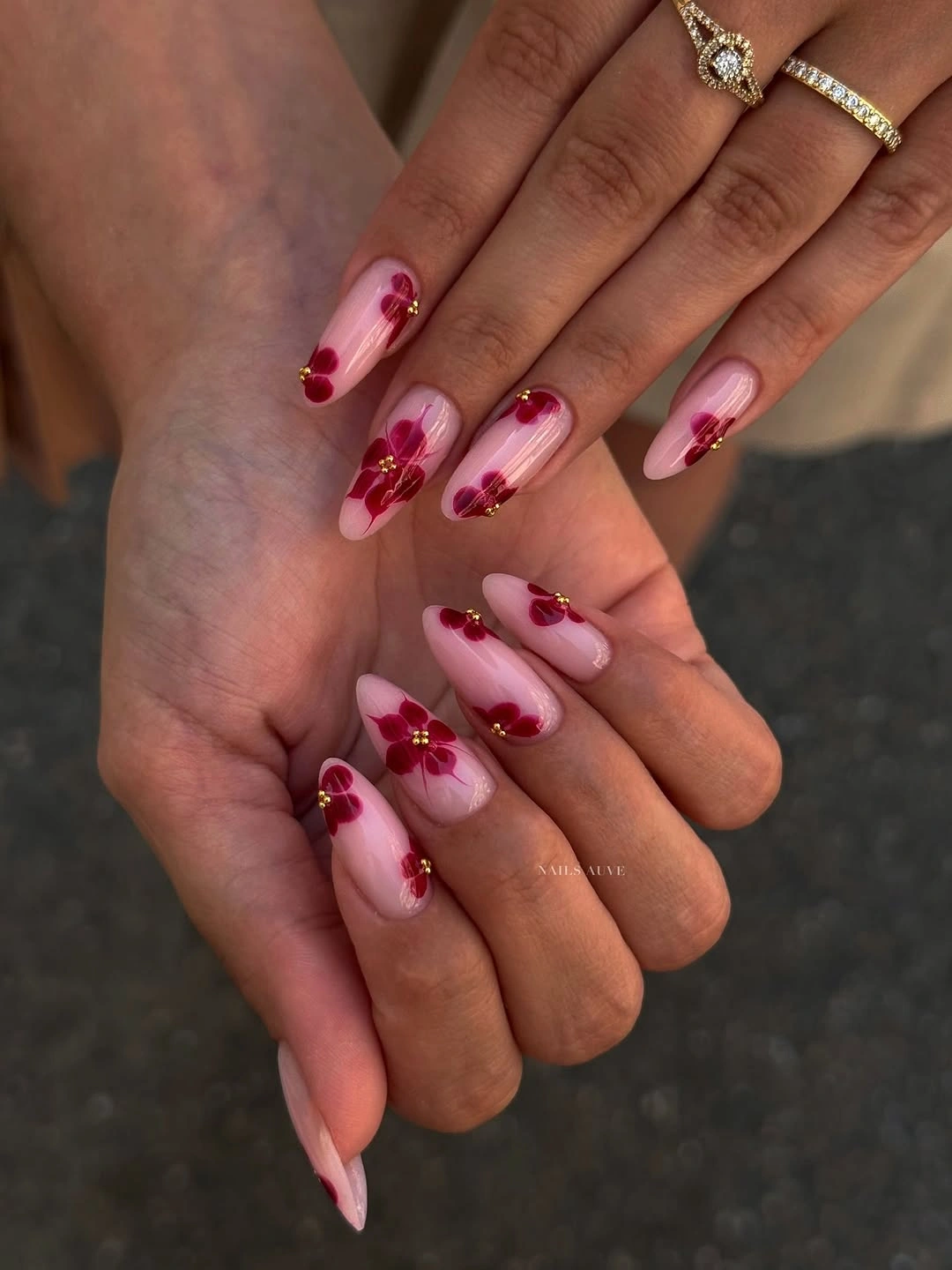 Blush pink almond wedding nails with small burgundy floral dot accents