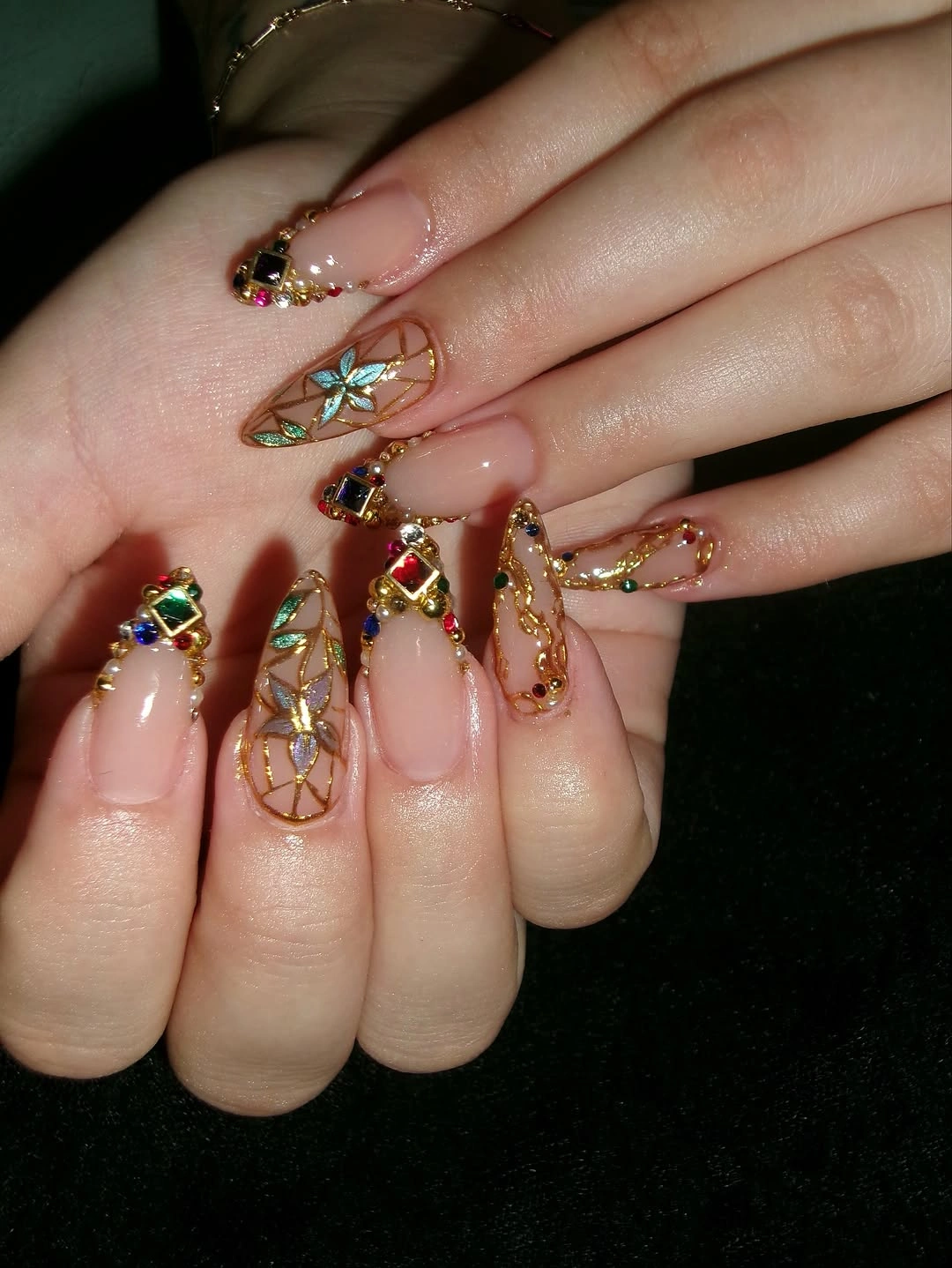 Long neutral coffin wedding nails with colorful jewel clusters chains and floral charms