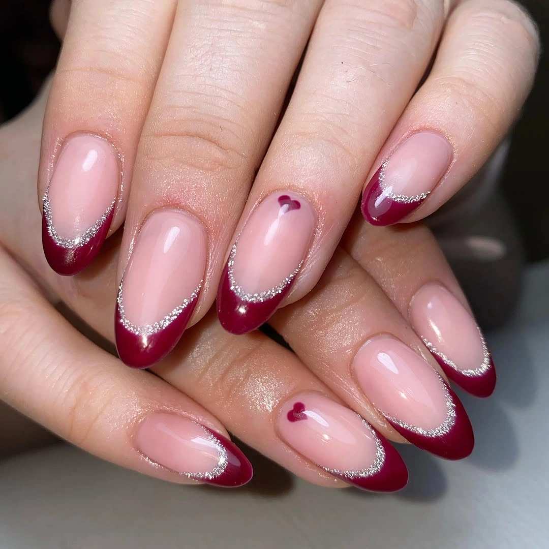 Blush pink almond wedding nails with berry French tips and heart accents