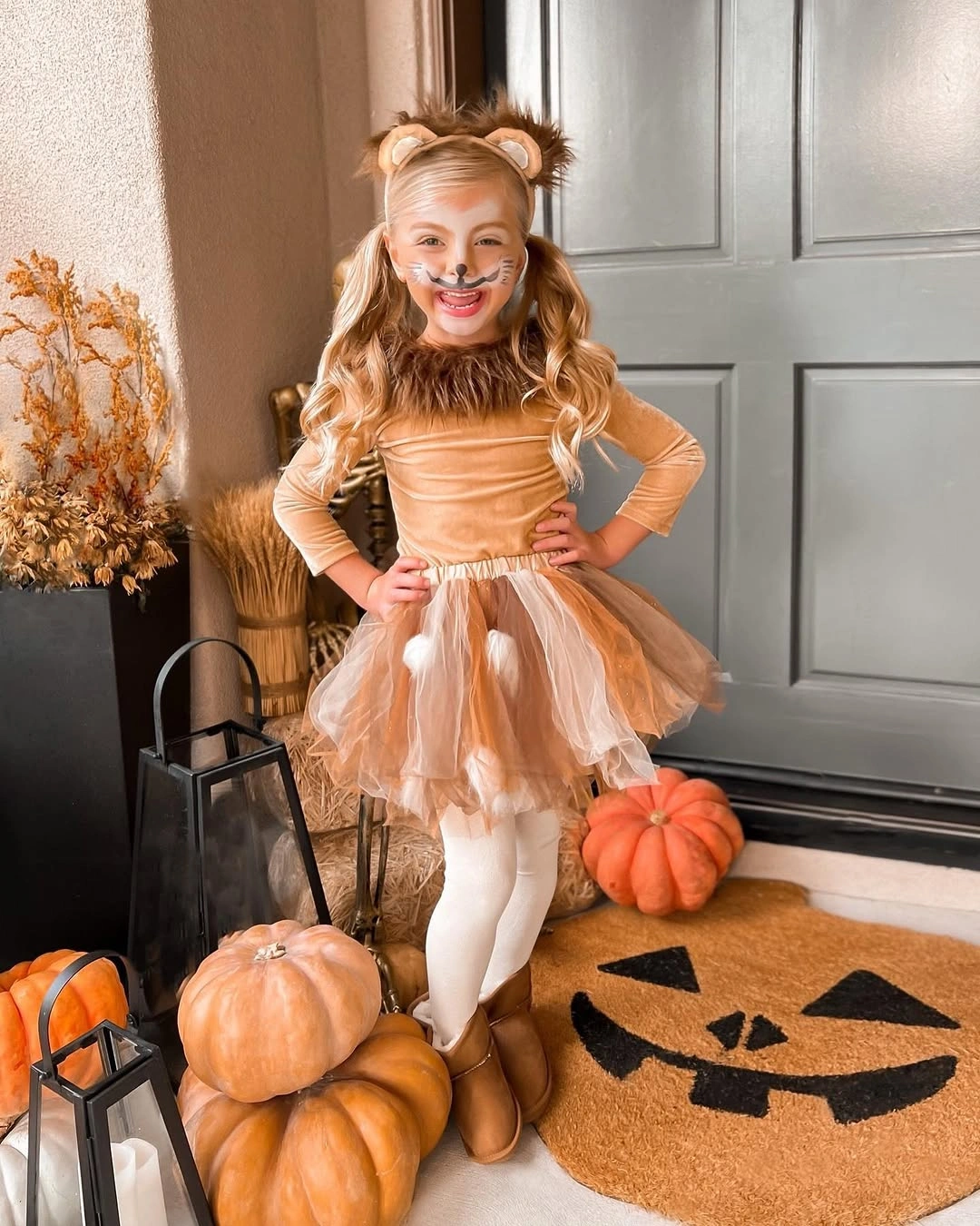Child in gentle deer Halloween costume with deer ears tan top tulle skirt white belly patch tights and brown boots