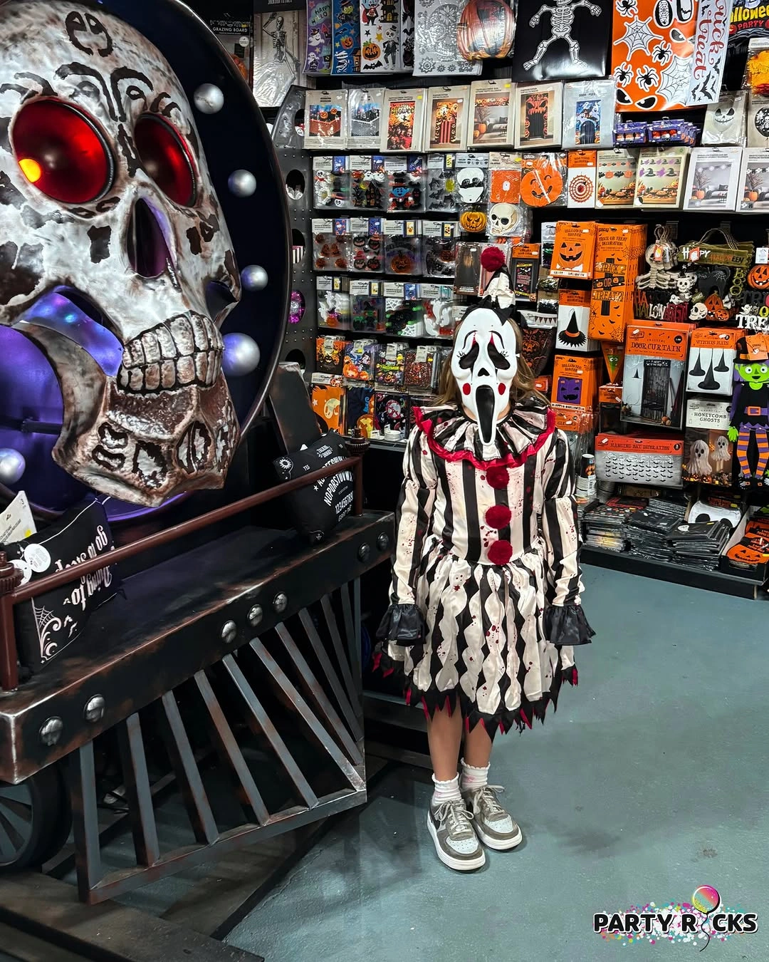 Child in black-and-white skeleton clown Halloween costume with a large white ruff and face paint