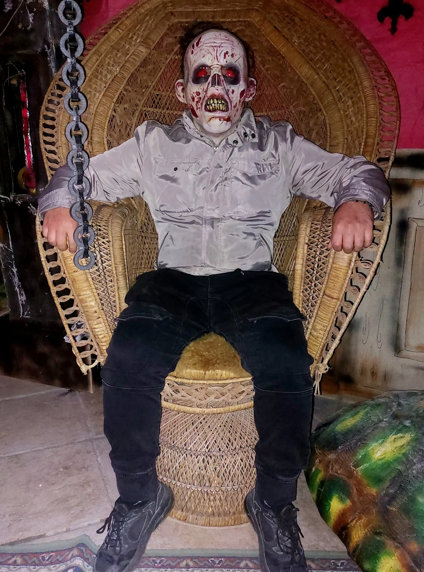 Child in undead zombie Halloween costume with white shirt black trousers black boots dark makeup and chain prop