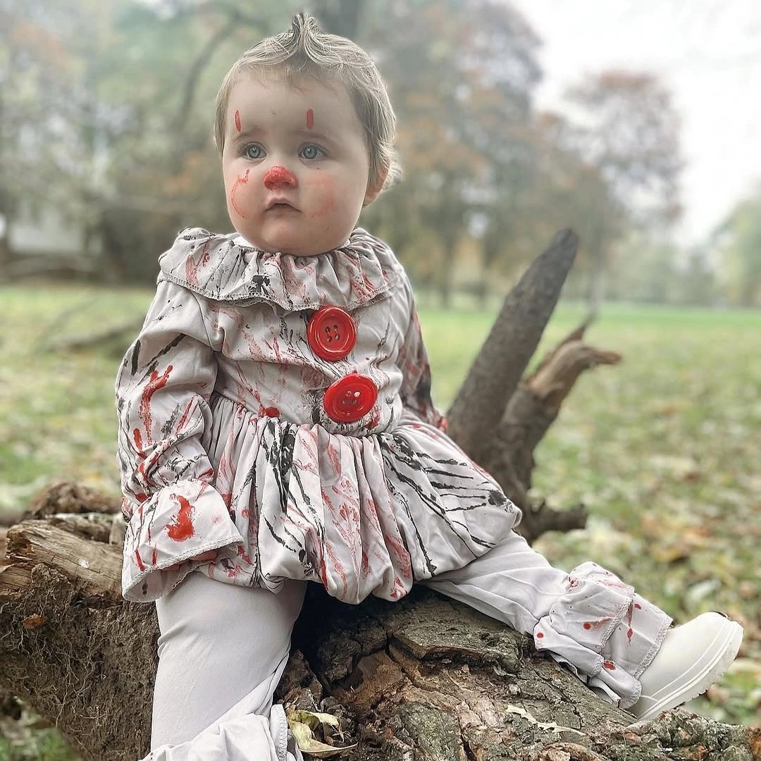 Toddler Pennywise from IT costume with pale ruffles red pom-poms white sneakers and face paint