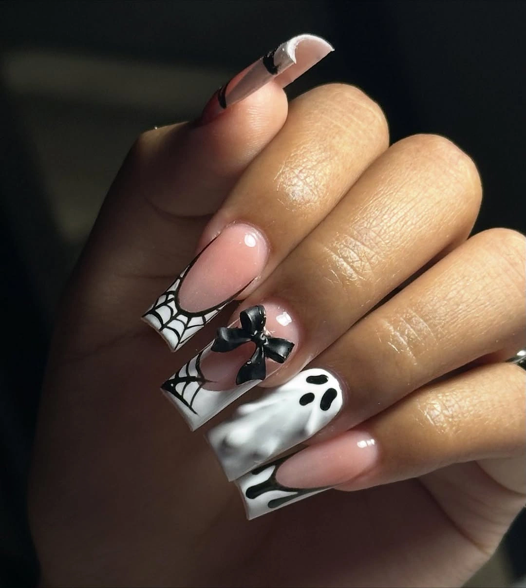 Medium almond nude nails with black white webs and small spooky details