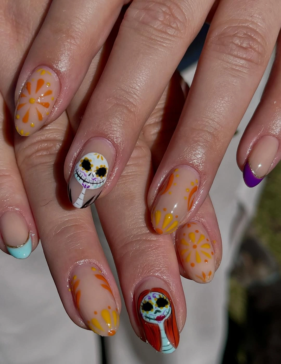 Medium almond pastel nails with colorful Halloween face motifs
