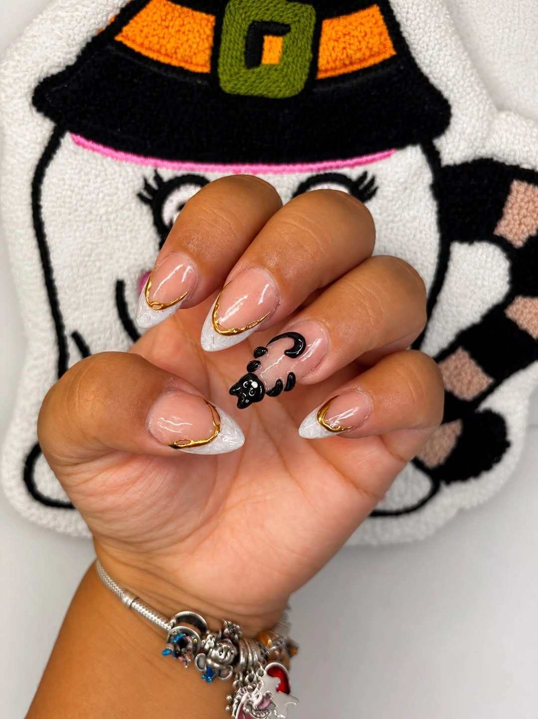 Short warm nude nails with tiny black orange and pale Halloween symbols