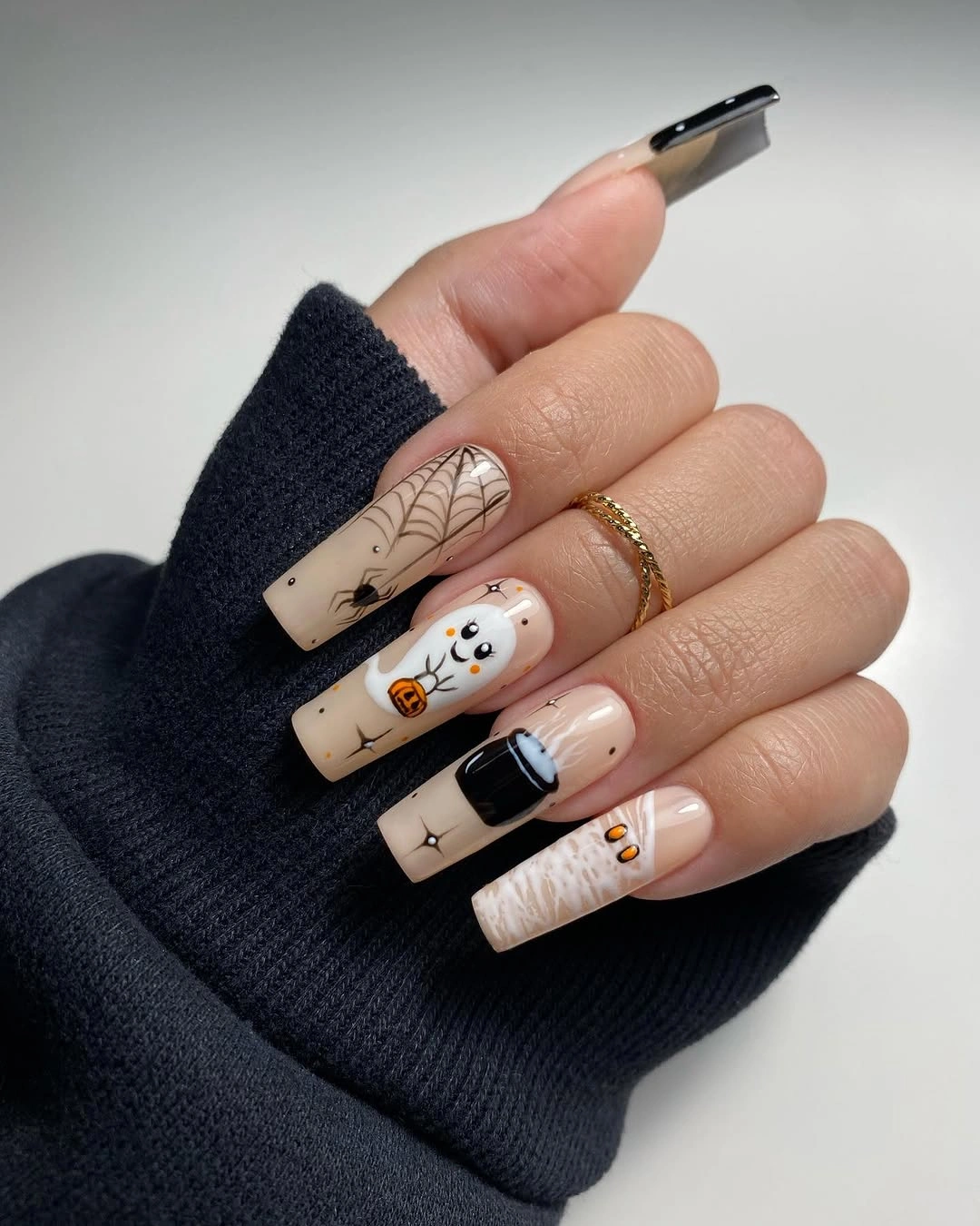 Long square nude nails with black tips and Halloween line art