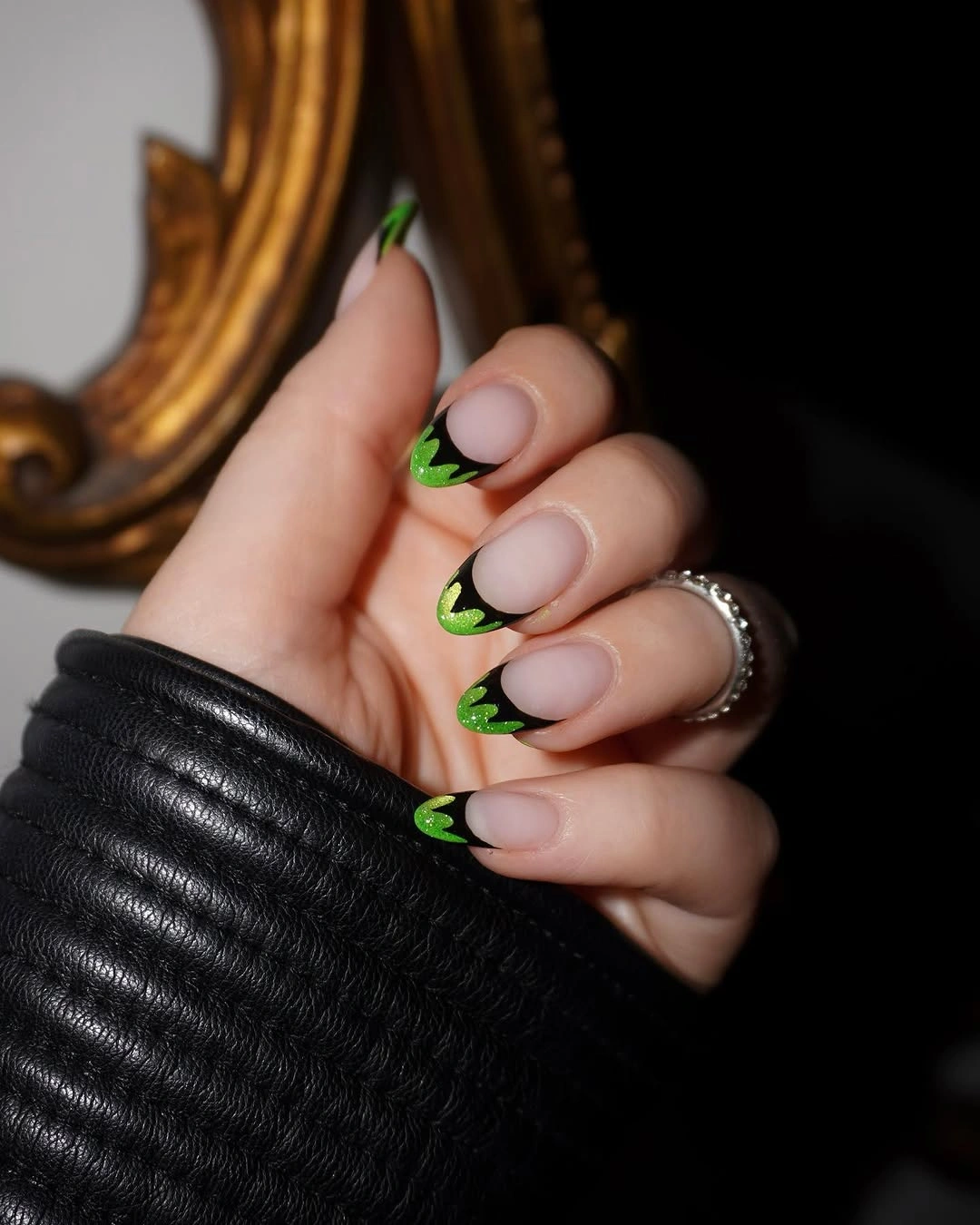 Short nude nails with neon green tips and small Halloween marks